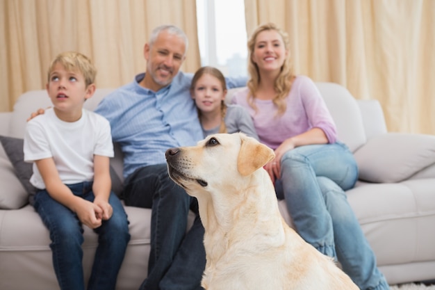 Les parents et leurs enfants sur le canapé avec chiot