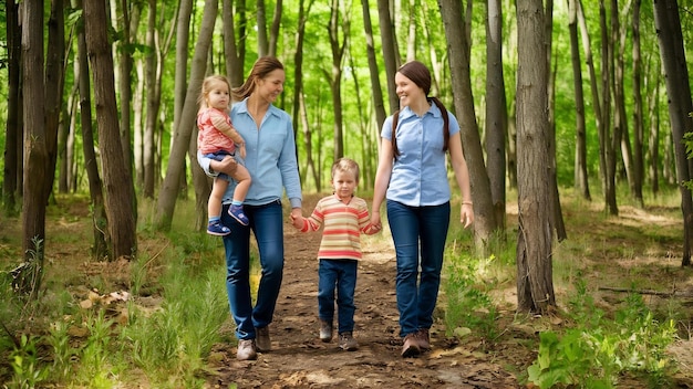 Des parents avec leurs enfants se promènent dans la forêt.