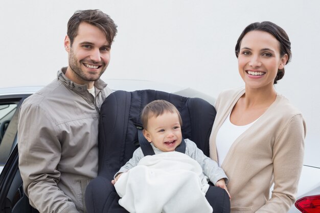 Parents portant bébé dans son siège d&#39;auto