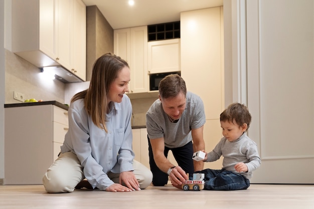 Parents souriants plein coup jouant avec un enfant