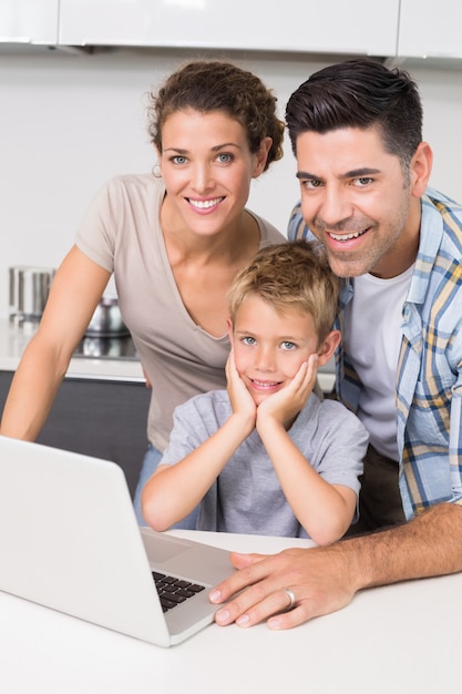 Parents souriants utilisant un ordinateur portable avec leur fils