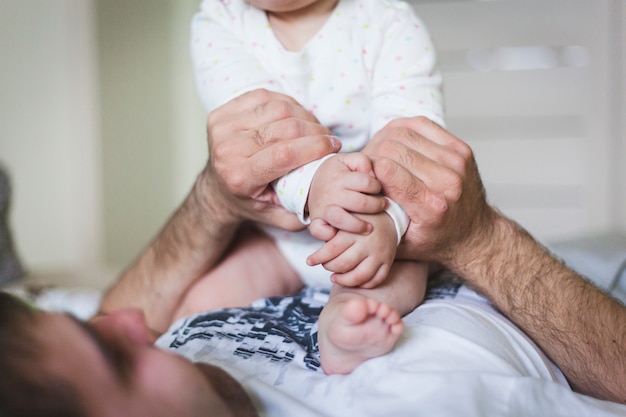 Les parents tiennent dans leurs mains les nuits de leur fille nouveau-née, le bonheur de la famille