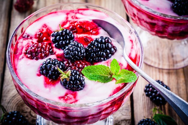 Parfait au yaourt dessert sain avec mûre et menthe en verre sur une table en bois rustique