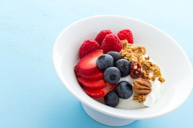 Parfait aux fruits frais et granola dans un bol blanc.