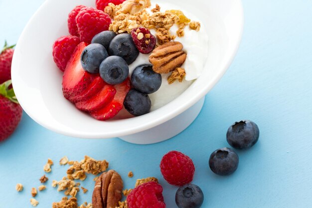 Parfait aux fruits frais et granola dans un bol blanc.