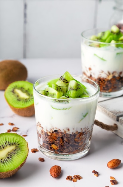 Photo parfait granola fait maison avec des kiwis dans des verres petit-déjeuner sain