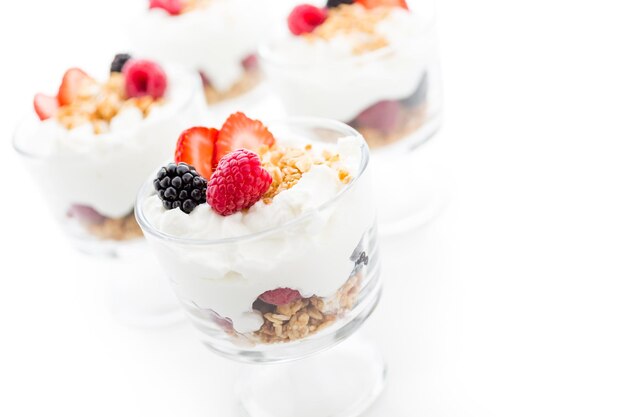 Parfait pour le petit-déjeuner à base de yogourt grec et de granola garni de baies fraîches.