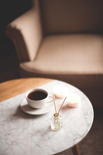 Parfum d'ambiance liquide dans une bouteille en verre avec une tasse de thé