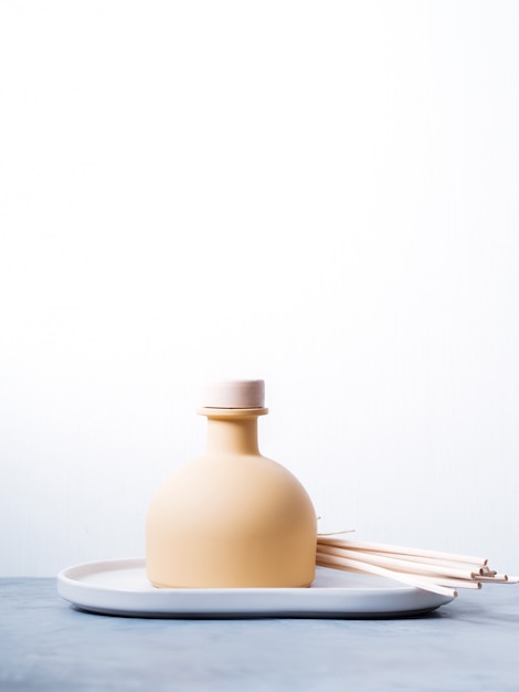 Photo parfum d'ambiance reed diffuseur avec bâtons de rotin sur un fond clair