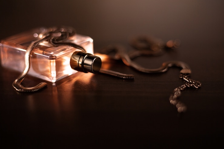 Photo parfum féminin et collier en or