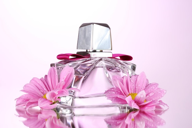 Parfum féminin dans une belle bouteille et fleurs isolées sur blanc