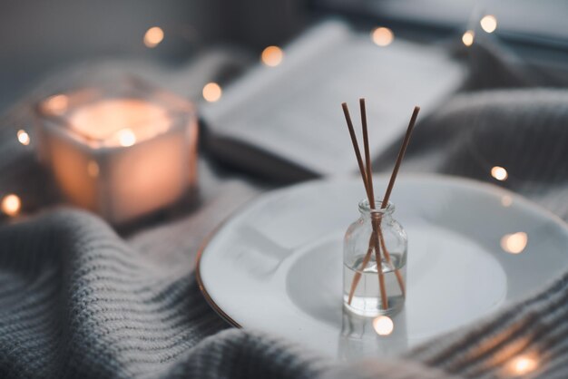 Parfum liquide à la maison dans une bouteille en verre brille les lumières de Noël