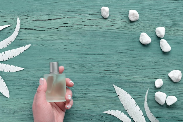 Parfum naturel Flacon de parfum en verre dépoli vert à la main avec des ongles manucurés