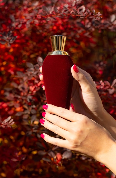 Parfum de parfum rouge à la main présentant un parfum de parfum présentant un produit de parfum