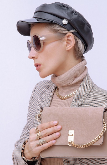 Paris Lady en tenue élégante à la mode Casquette et lunettes de soleil à la mode Pochette en velours beige Style dans les détails Saison automne hiver Amant rétro vintage