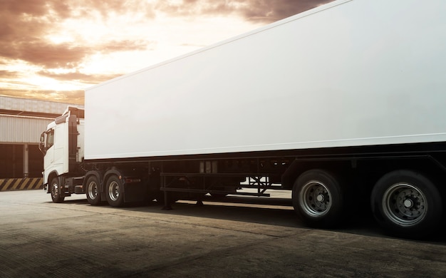 Parking de camions semi-remorques au coucher du soleil Sky Road Logistique des camions de fret et concept de transport de fret