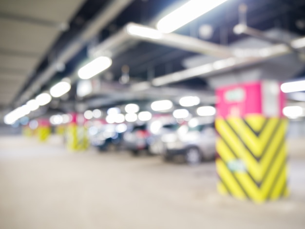 Parking souterrain avec voitures, intérieur industriel. Néon dans un bâtiment industriel lumineux.