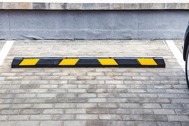 Un Parking Vide Dans Un Quartier Résidentiel Avec Des Arrêts De Stationnement Jaunes Pour Les Voitures. Fermer. Arrêtez Le Limiteur De Stationnement.