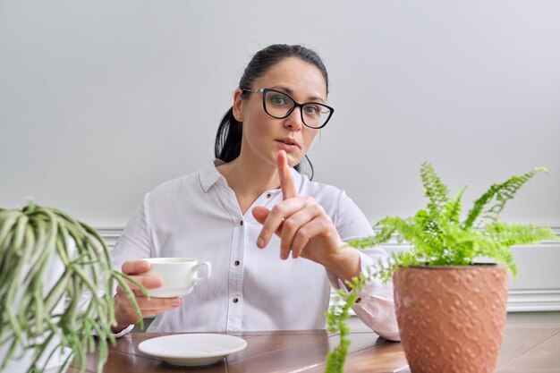 Parler d'une femme d'affaires positive regardant la caméra en gros plan