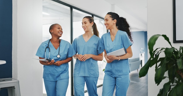 Parler des infirmières marcher et des documents dans l'hôpital travail d'équipe diversité collaboration ou l'attachement sur la chirurgie ou la clinique pause Sourire heureux et les femmes de la santé avec un document de recherche médicale ou une blague drôle