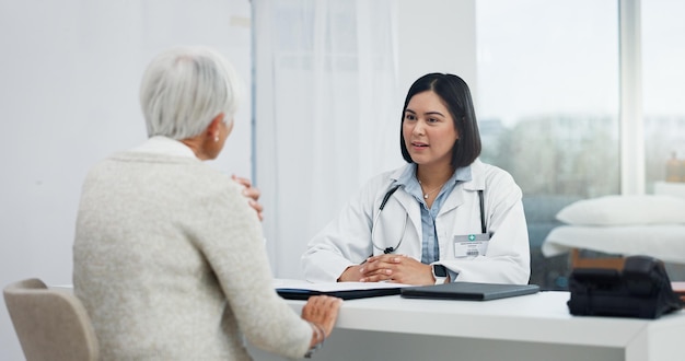 Parler de soins de santé et un médecin avec un problème de douleur à l'épaule d'une femme âgée et un soutien dans un bureau Consultation hospitalière et une infirmière parlant à un patient âgé de conseils médicaux