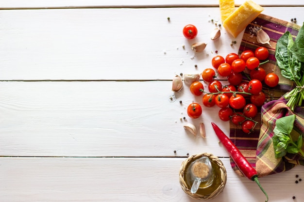 Parmesan, tomates, huile d&#39;olive et autres ingrédients pour la vinaigrette. Fond blanc.