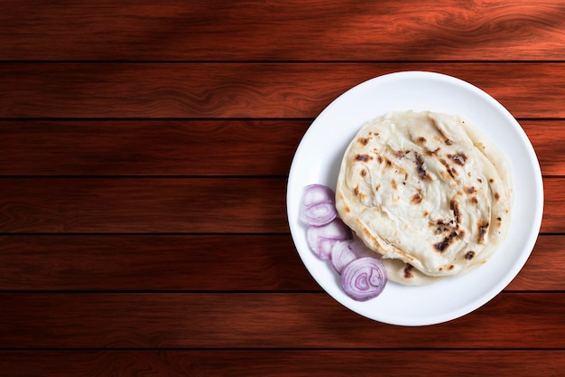 Parotta de cuisine indienne avec oignon sur fond de bois Vue de dessus avec espace de copie