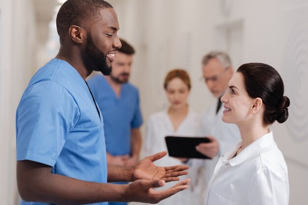 Partager une expérience intéressante. Des médecins impliqués et sympathiques prenant une pause-café à l'hôpital et exprimant leur intérêt tout en partageant des idées