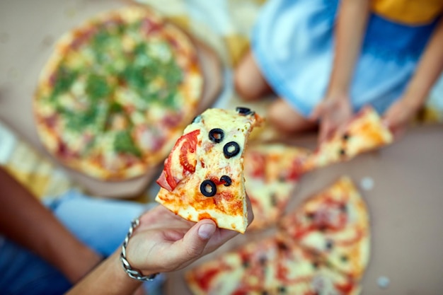 Partager des mains de pizza en prenant un morceau de pizza dans une boîte pique-nique familial en plein air manger des pizzas pour le dîner livraison de restauration rapide