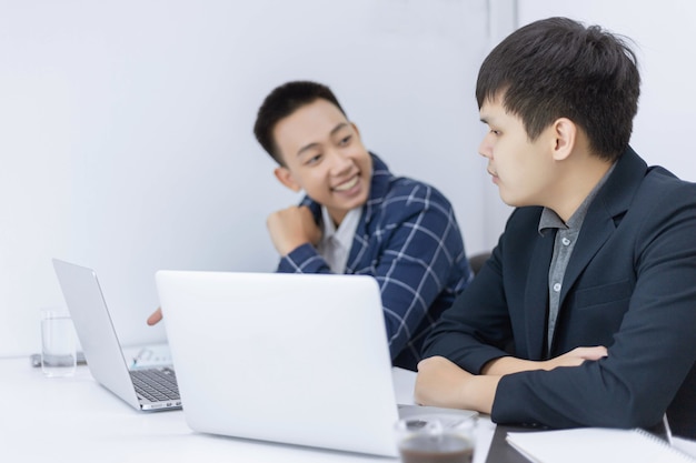 Les partenaires commerciaux conçoivent un jeune homme d'affaires parlant à son collègue d'un plan marketing du nouveau produit à venir.