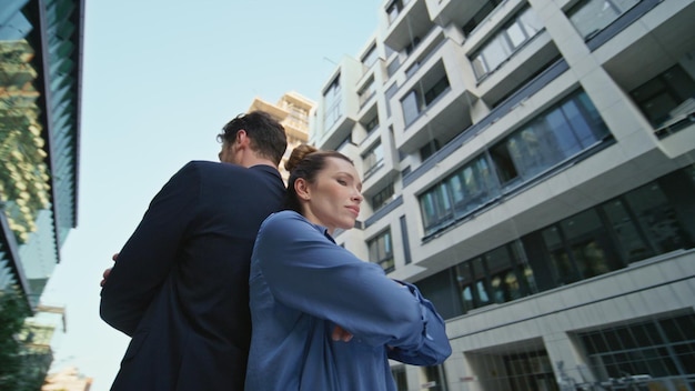 Photo des partenaires commerciaux se croisent les mains en posant devant des collègues du district urbain debout.