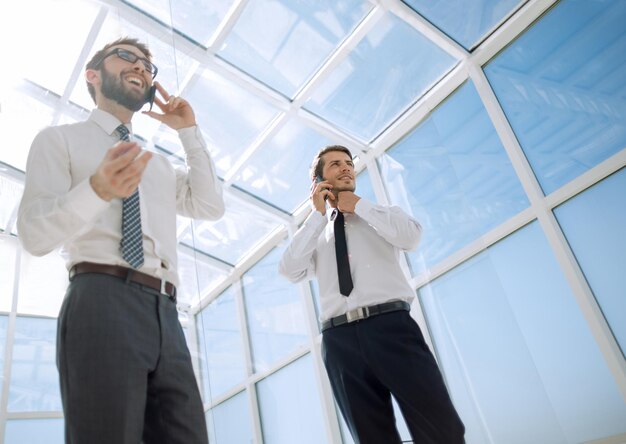 Les partenaires commerciaux de la vue de dessous parlent sur un téléphone mobile le concept de communication