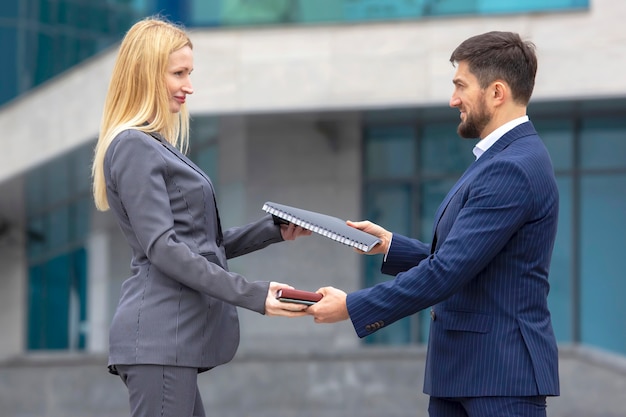 Partenaires d'hommes d'affaires prospères sur le fond d'un bâtiment commercial avec des documents