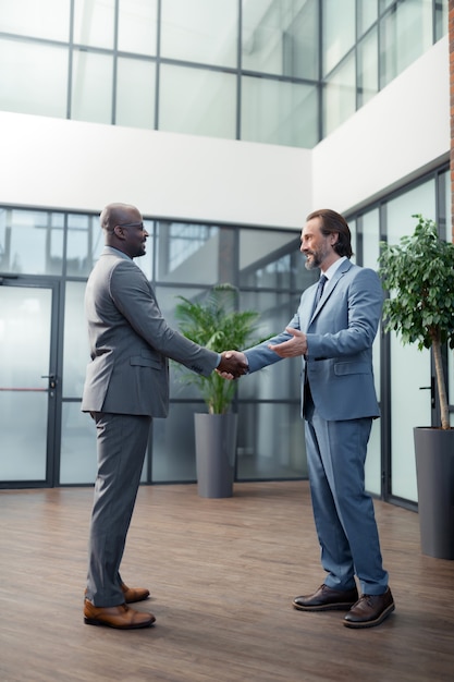 Partenaires se serrant la main. Homme d'affaires à la peau foncée serrant la main de son partenaire commercial avant de se rencontrer