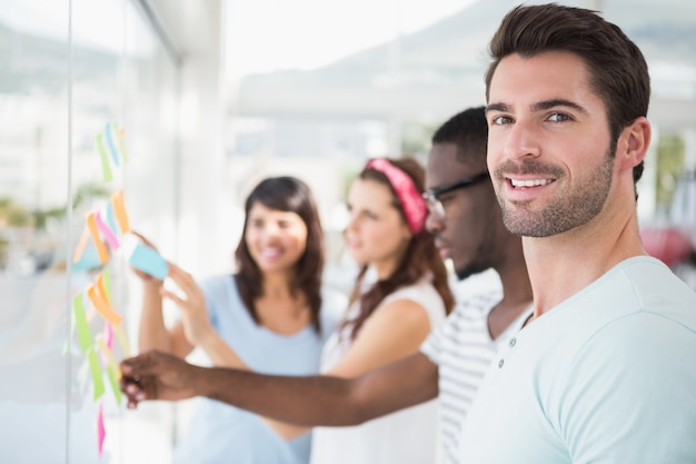 Partenaires souriants interagissant et lisant des notes autocollantes