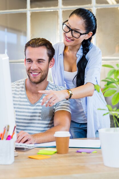 Partenaires souriants travaillant ensemble sur ordinateur