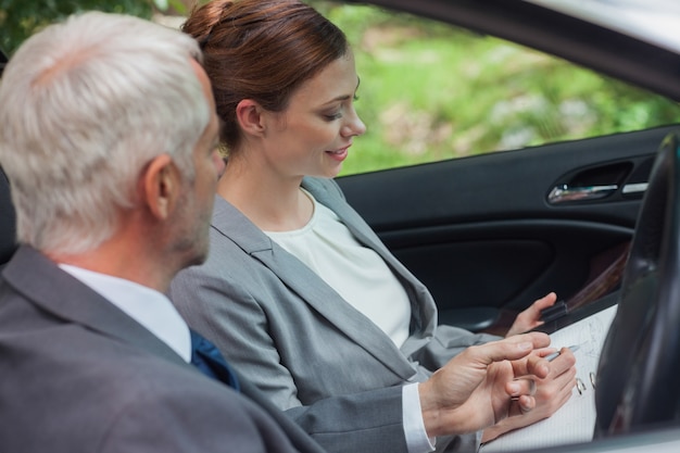 Partenaires travaillant ensemble dans une voiture chic