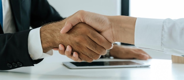 Photo partenariat deux hommes d'affaires se serrant la main après la signature d'un contrat dans la salle de réunion du bureau de l'entreprise entretien d'embauche investisseur succès négociation partenariat travail d'équipe concept financier