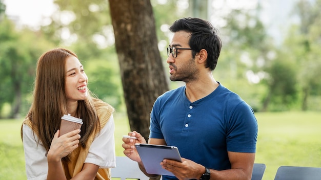 Partenariat Étudiant Ami tenant un parapluie et travaillant à l'étude avec le soutien du partenaire ensemble au parc Business young Couple Partner Discuter à l'extérieur Collègues d'affaires à l'extérieur du bureau A Couple