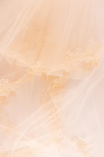 Photo partie d'un beau tissu de tulle en dentelle beige ou partie d'une robe de mariée de mariée sur un fond de satin beige espace pour le texte disposition de conception