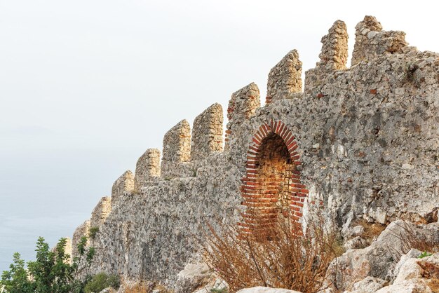 Photo une partie du mur de la forteresse sur une colline surplombant la mer d'alanya