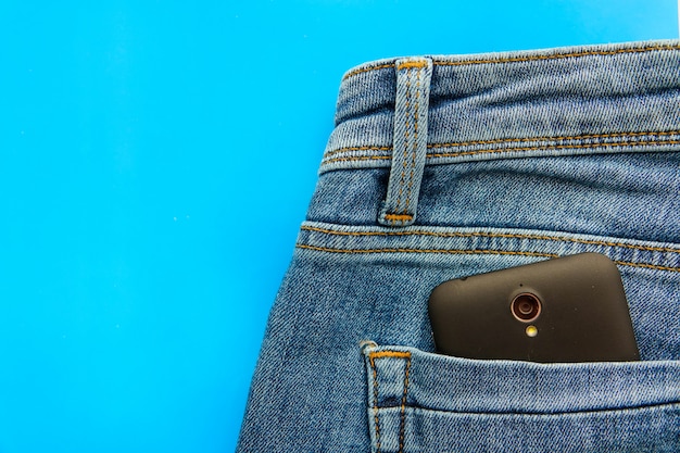 Partie du téléphone portable dans la poche arrière d&#39;un jean bleu