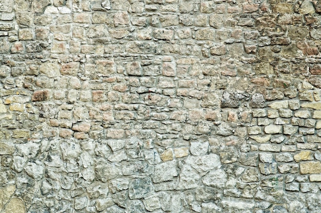 Une partie du vieux mur de briques antique de pierres grises