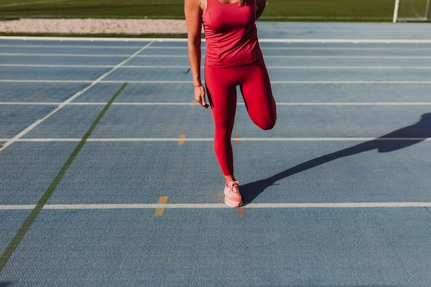 La partie inférieure d'une athlète féminine s'entraînant sur une piste sportive