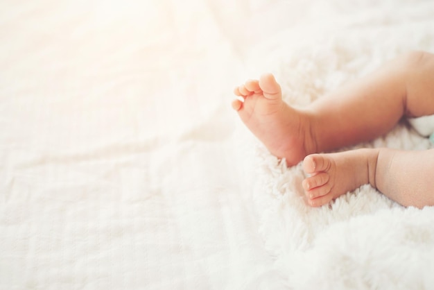 La partie inférieure du bébé allongé sur le lit