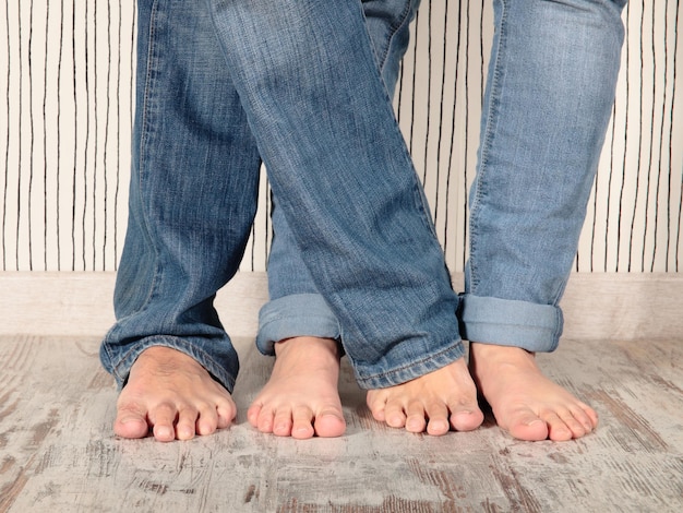 La partie inférieure du père et du fils portant des jeans