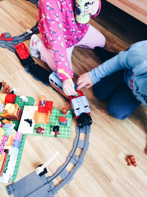 Photo la partie inférieure des enfants jouant avec un train jouet à la maison