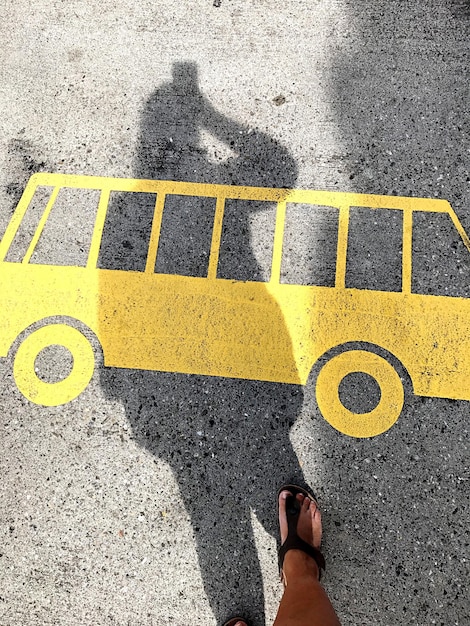 Photo la partie inférieure d'une femme debout près d'un panneau sur la route