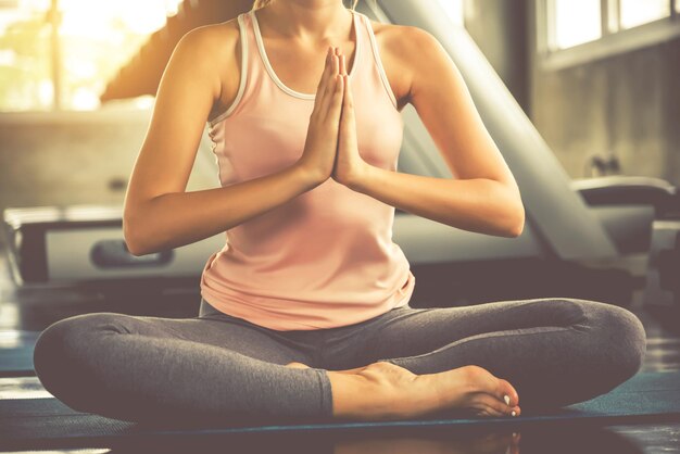 Photo la partie inférieure d'une femme faisant du yoga alors qu'elle est assise au gymnase