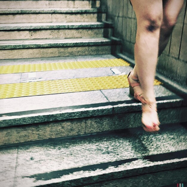 La partie inférieure d'une femme marchant sur des marches